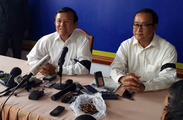 Pressekonferenz mit Trauerflor: Oppositionsführer Sam Rainsy und Kem Sokha zeigten sich am Samstag solidarisch mit den Opfern vom Freitag. Mittlerweile wurde gegen beide ein rein politisch motivierter Haftbefehl ausgestellt. (Foto: PRKN)